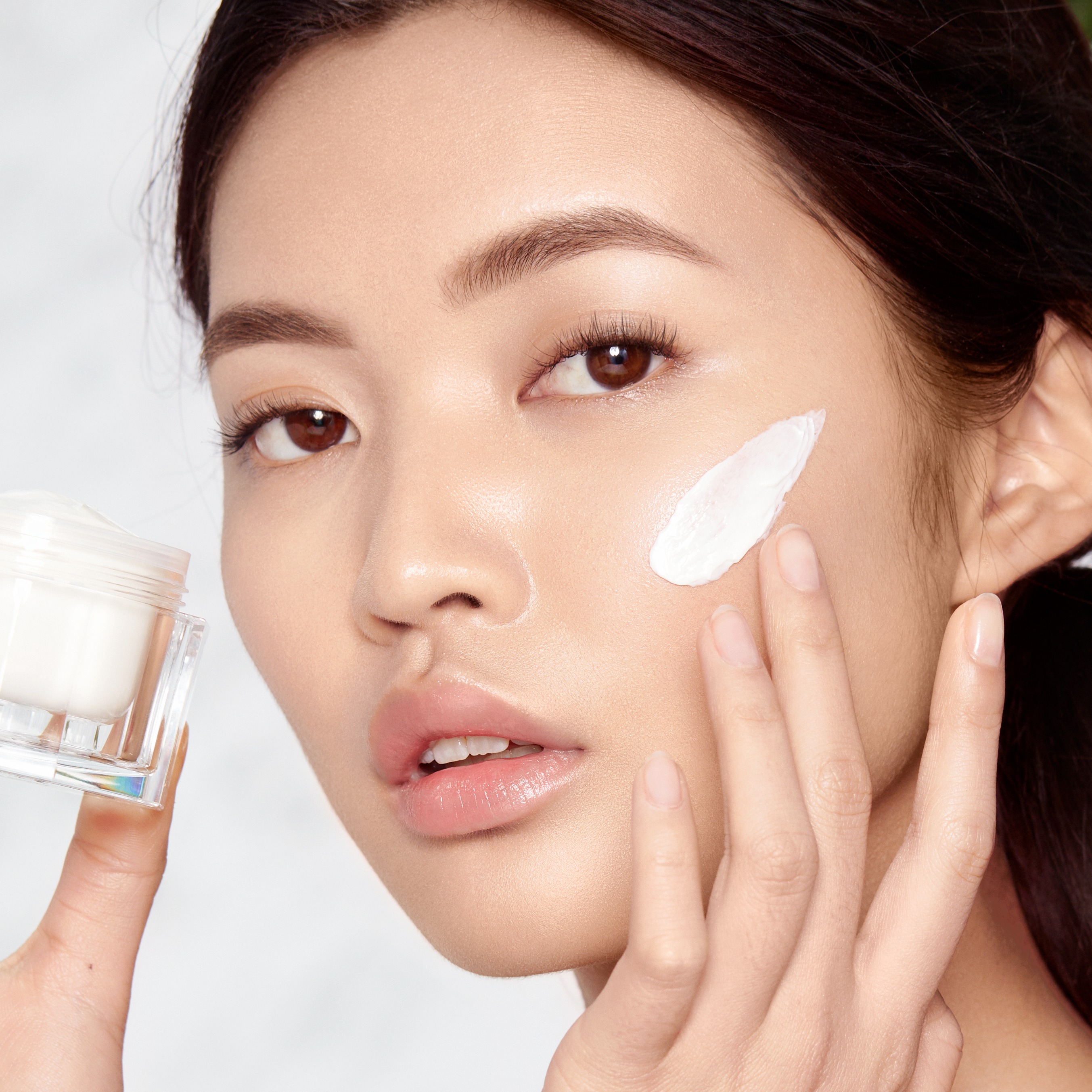 Dermatologist demonstrating how to apply face serum on British actress Lily James