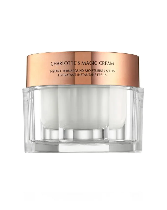 A pearly-white cream in a glass jar with a metallic, golden-coloured lid which has 'Charlotte's Magic Cream' written on it. 